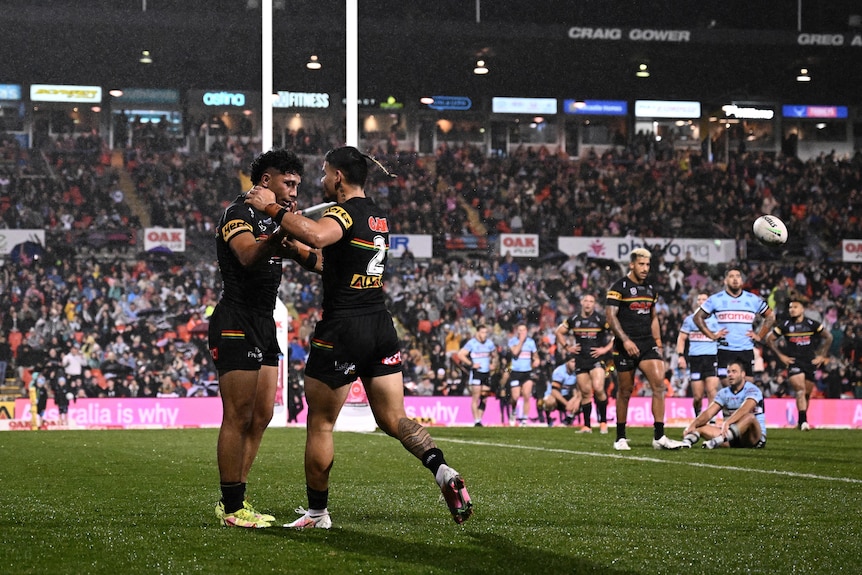 Izack Tago and Taylan May hug after a try in the Penrith Panthers' NRL game against Cronulla Sharks.