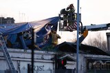 Rescue workers cover the wreckage of a police helicopter which crashed onto the roof of the Clutha Vaults pub in Glasgow.