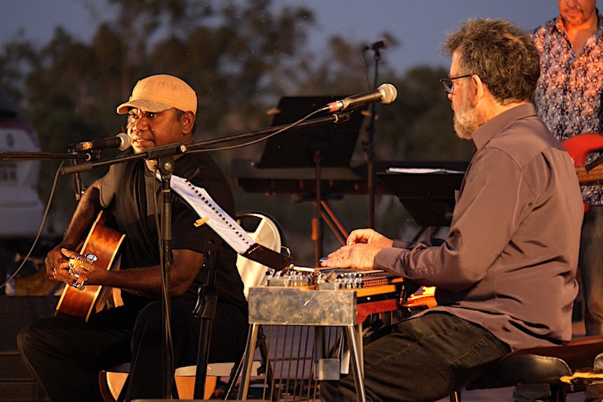 Two men singing and playing music.