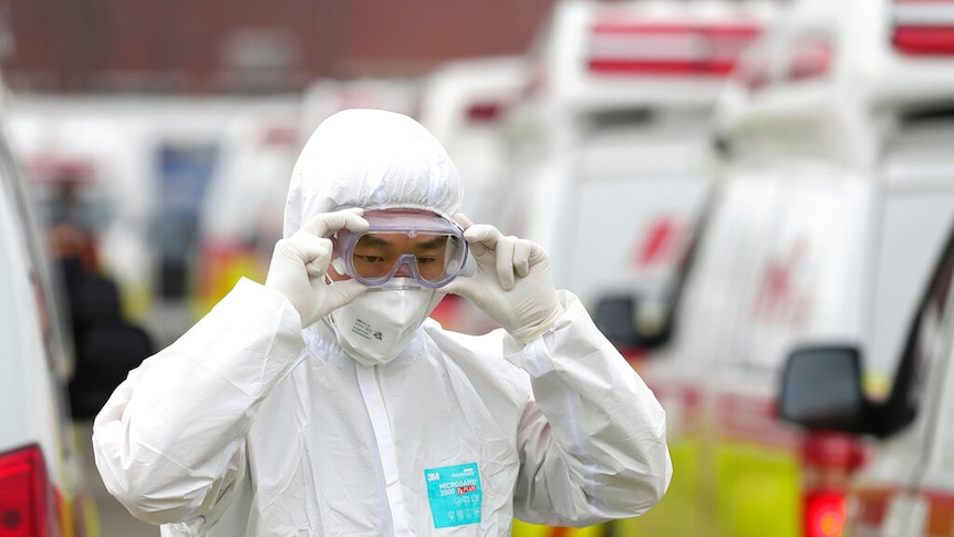 A man in full protective suit adjusts his goggles in South Korea.