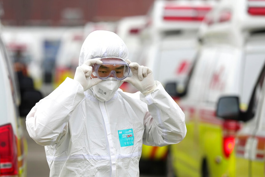 A man in full protective suit adjusts his goggles in South Korea.