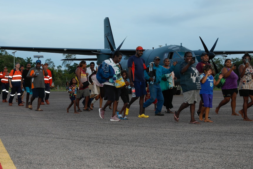 Borroloola residents prepare to board a RAAF C-130J Hercules aircraft evacuation flight in Borroloola on Wednesday night.