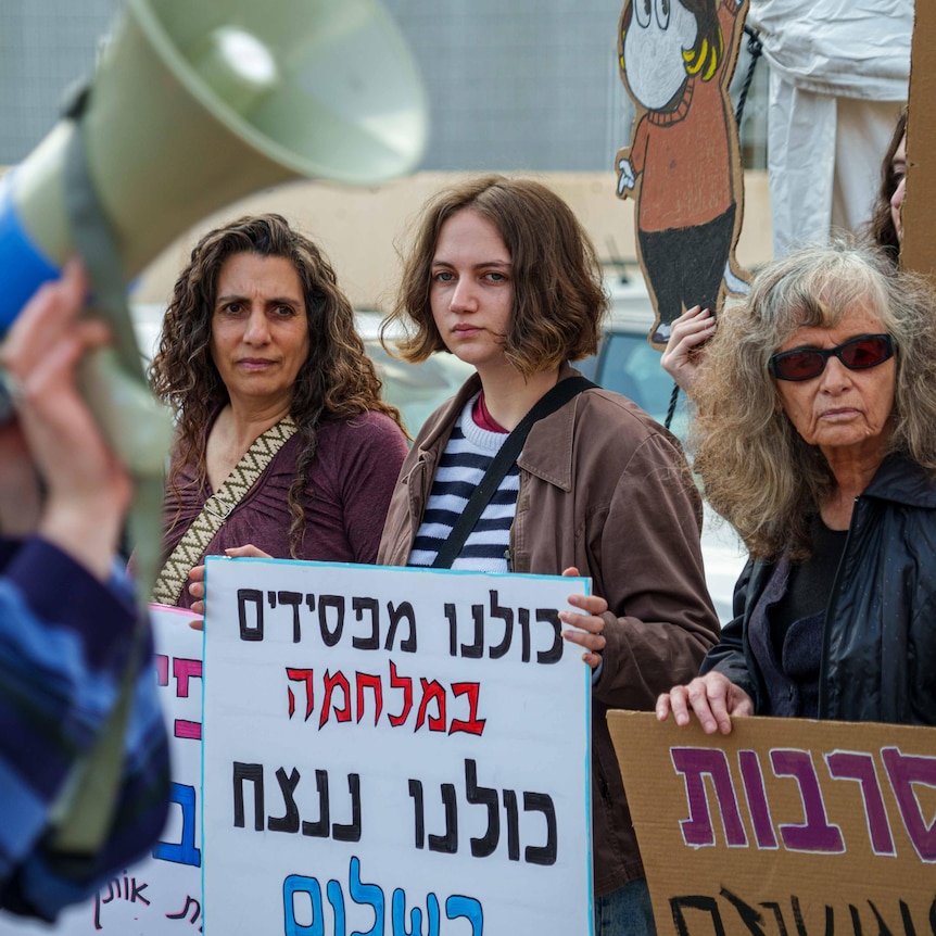 A young woman with a protest sign in Hebrew