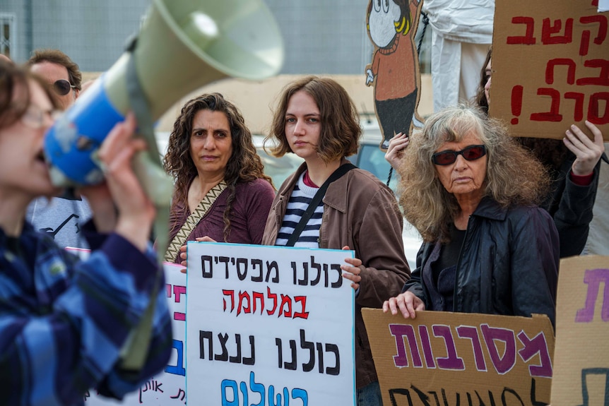 A young woman with a protest sign in Hebrew