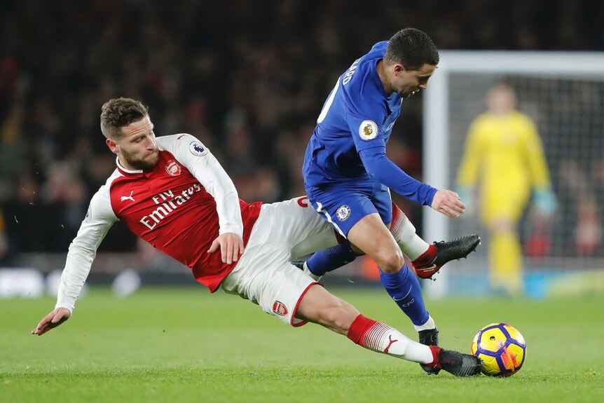 Eden Hazard competes with Shkodran Mustafi for the ball.