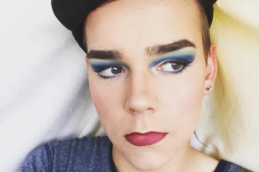 A young man in heavy makeup