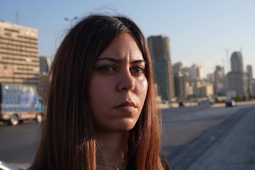 A woman stands on a street.