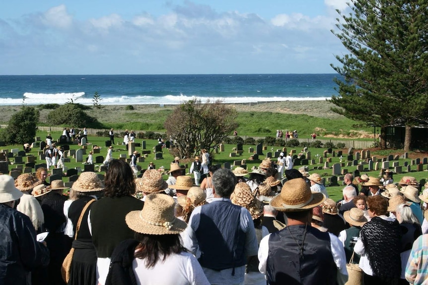 A crowd gathers at Norfolk Island cemetery.