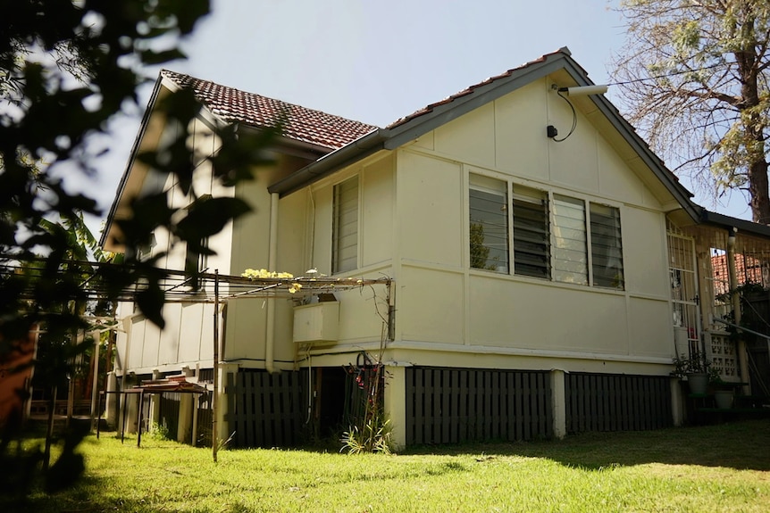 The exterior of a Queenslander-style suburban house.
