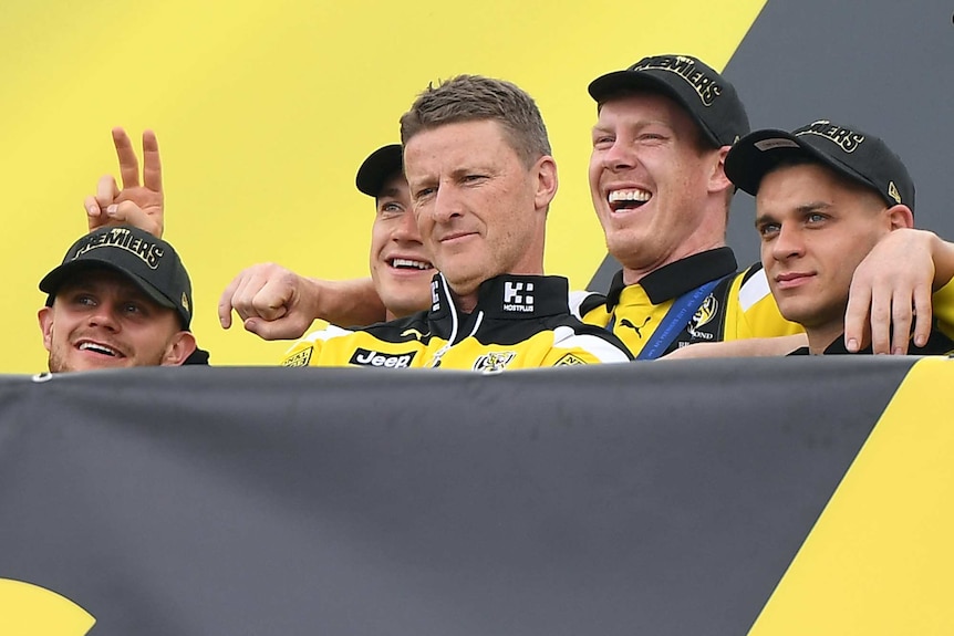 Damian Hardwick with Jack Riewoldt, Dustin Martin and other players.