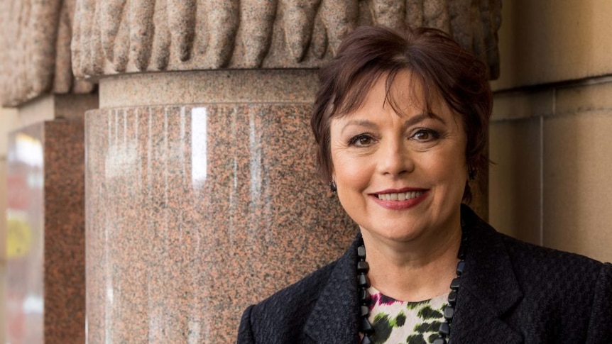 Kathryn Fagg stands in front of a marble pillar