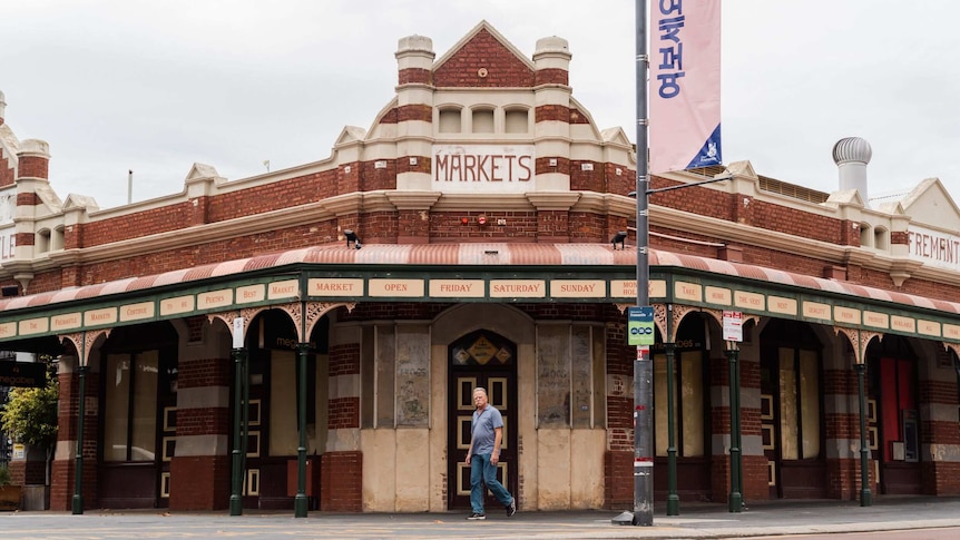 A man walks past the entrance to the shuttered Fremantle markets