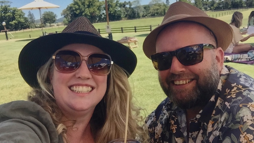 Vanessa Phillips and her husband Craig, pictured similing wearing sunglasses and hats.