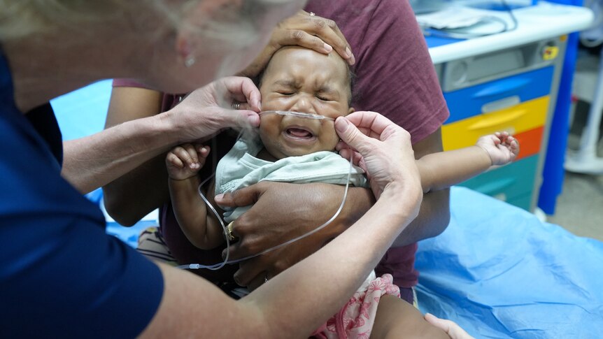 Baby being given oxygen by doctors.