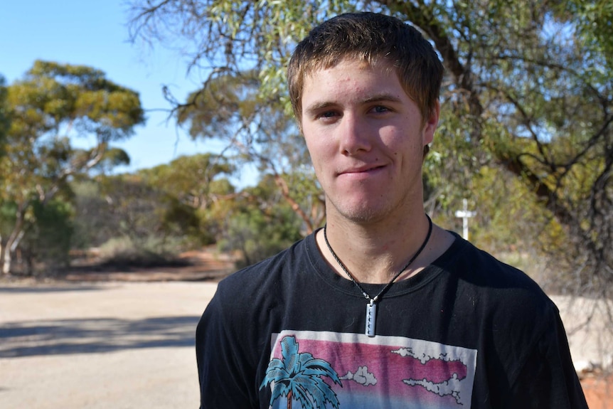 A young man looks at the camera