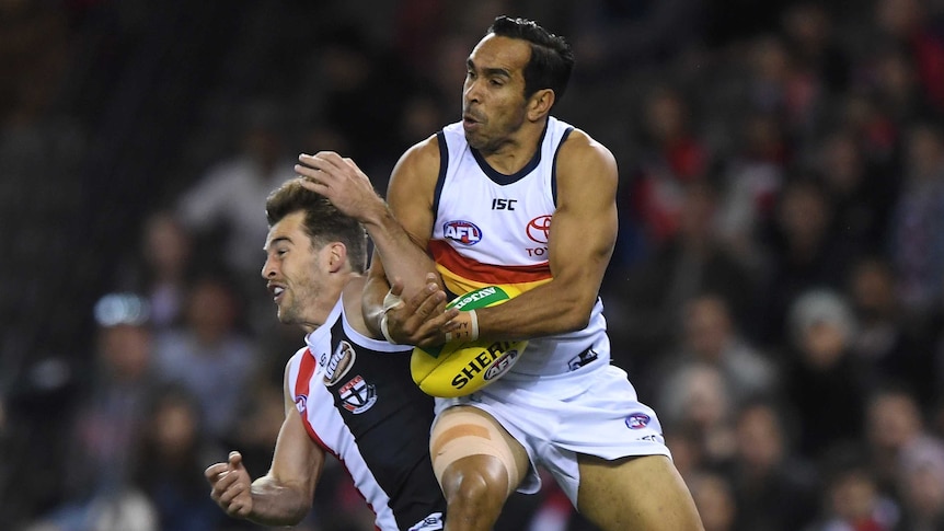 Eddie Betts catches the ball in the air, as he bumps Daniel McKenzie with his shoulder.