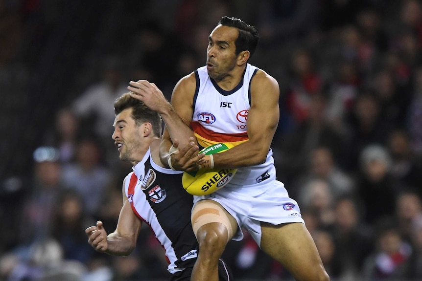 Eddie Betts atrapa la pelota en el aire, mientras golpea a Daniel McKenzie con su hombro.