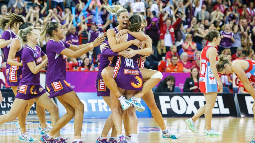 Queensland Firebirds celebrate after winning trans-Tasman netball grand final against NSW Swifts.