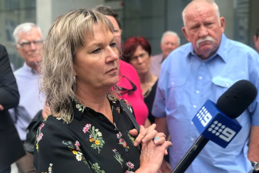 Amanda Spann, surrounded by supporters, speaks to reporters outside court