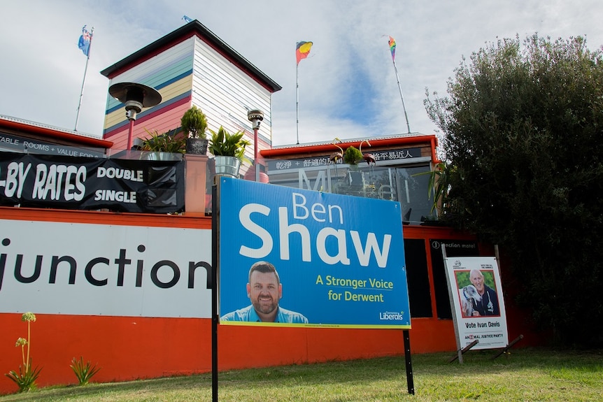 Two political campaign signs in front of a restaurant