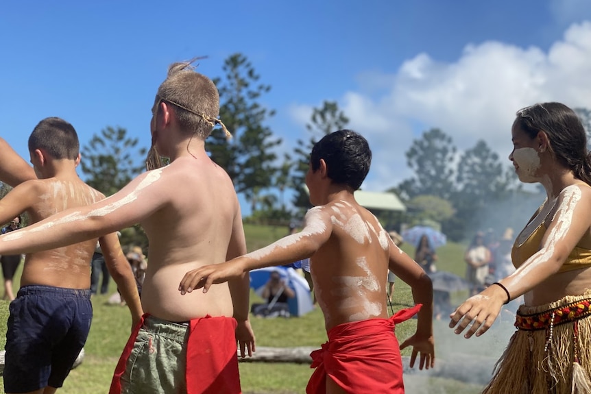 Indigenous boys at a smoking ceremony outside