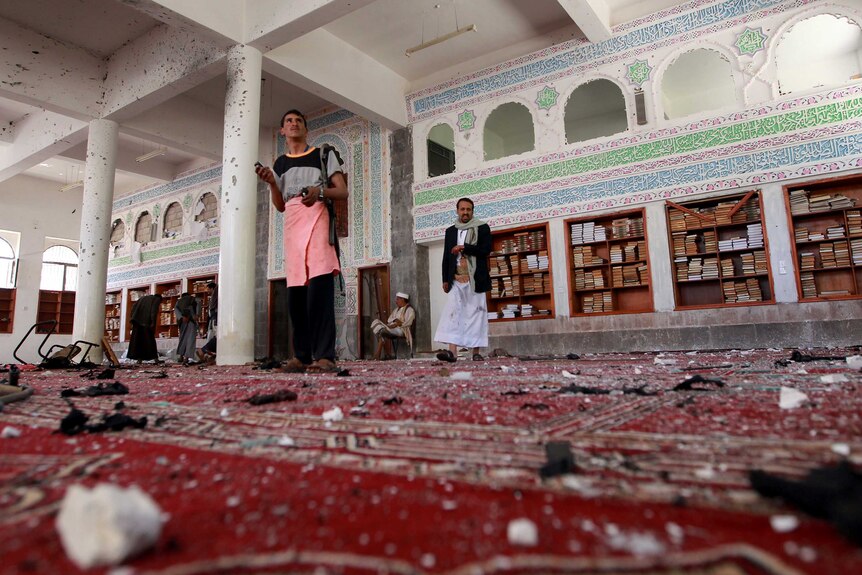 Men inspect the damage following a bomb explosion at the Badr mosque in southern Sanaa.