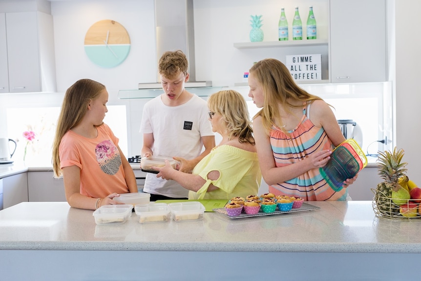 Kat Springer with her three teenagers in a busy kitchen.
