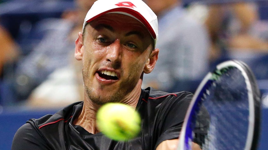 John Millman hits a ball during his match with Roger Federer.