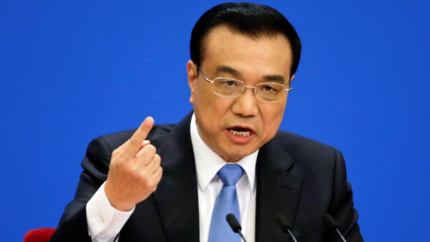 China's Premier Li Keqiang points a finger and gestures during a news conference.