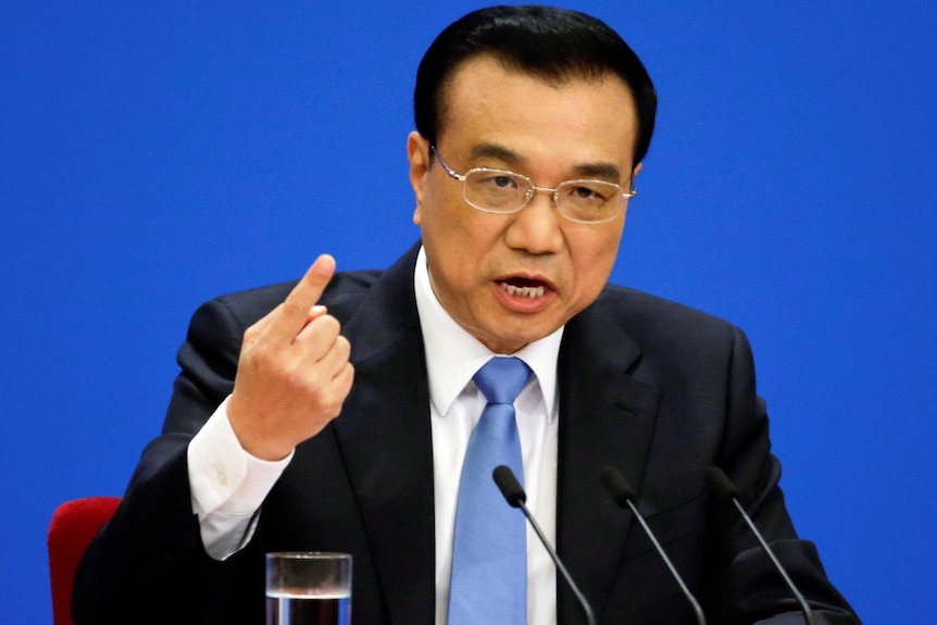 China's Premier Li Keqiang points a finger and gestures during a news conference.