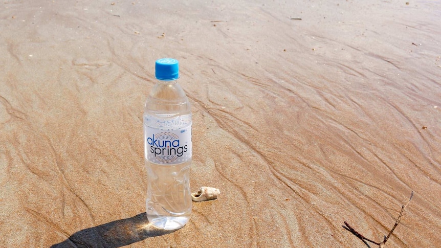 A bottle of Akuna Springs water on the beach.
