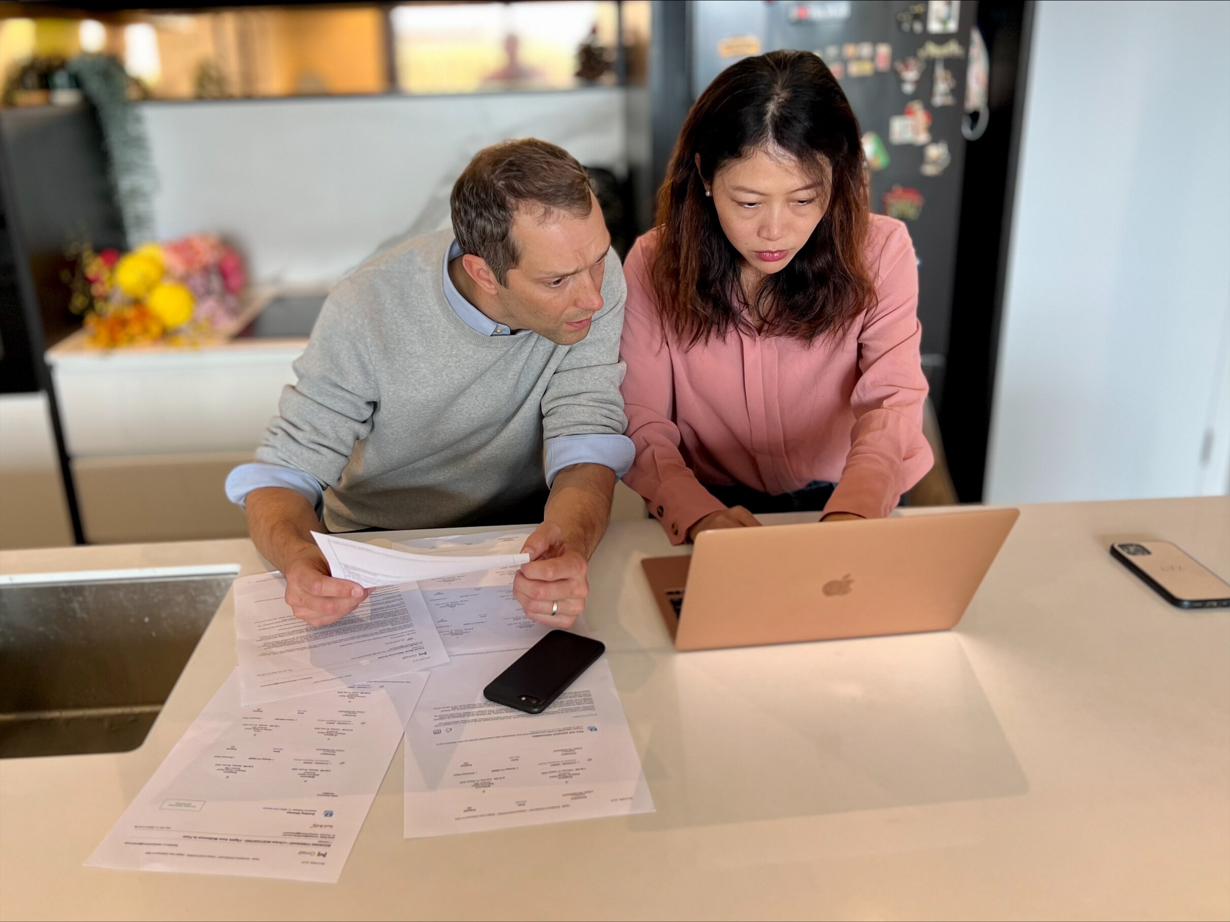 A man and a woman look at a laptop screen.