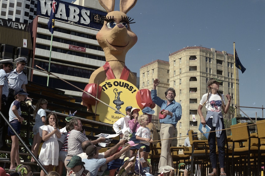 Rolh Harris on stage with children and a giant kangaroo behind him.