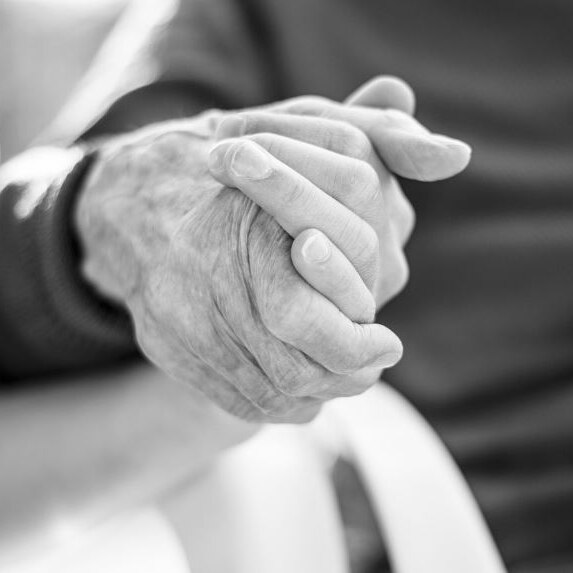 Black and white picture of two people holding hands 