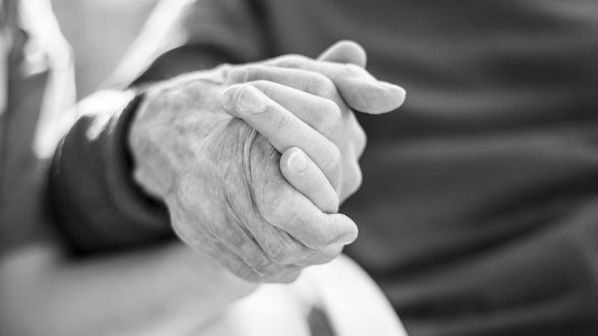 Black and white picture of two people holding hands 