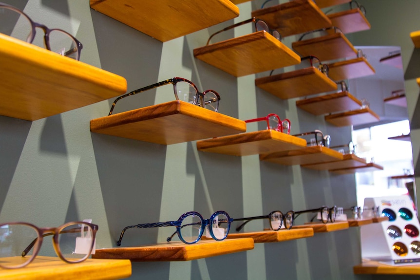 Glasses on small shelves on the wall viewed from the side