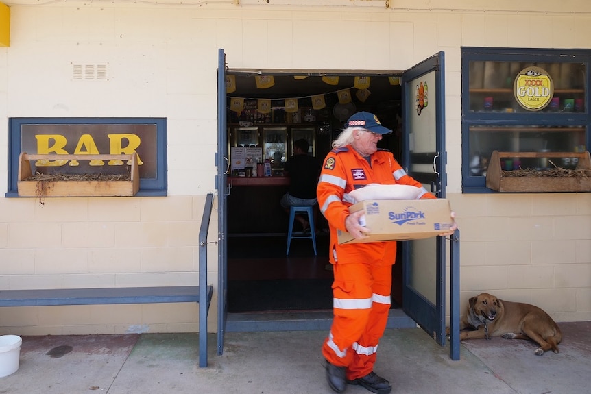 An SES volunteer with supplies from the Yandaran Hotel coolroom