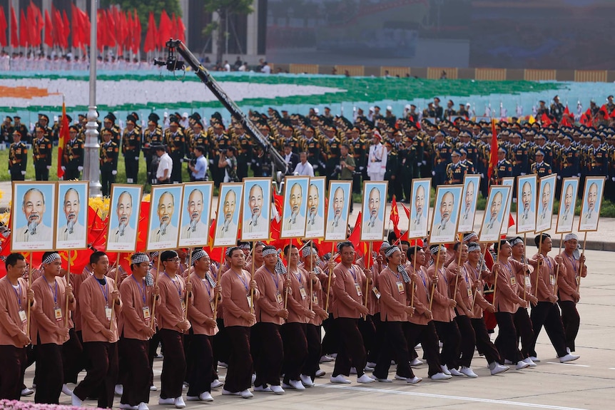 Farmers from Southern region of Vietnam hold placards with pictures of Ho Chi Minh.