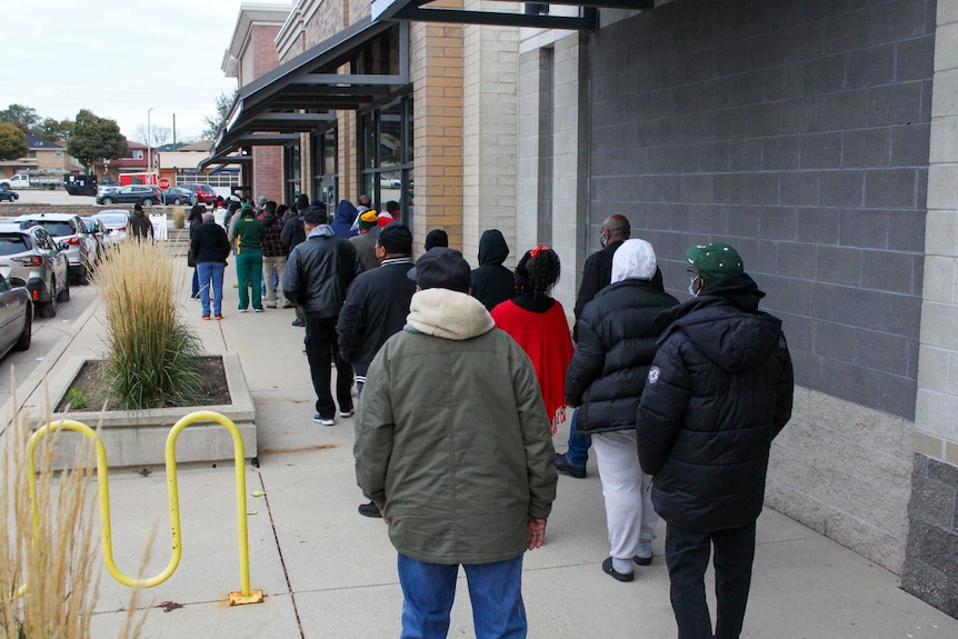 A long line of people standing outside a building