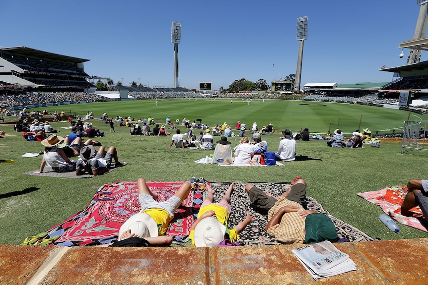 Spectators lie on the hill at the WACA