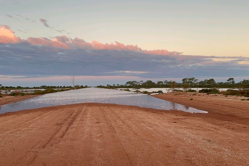 Water on a dirt road at sunset 