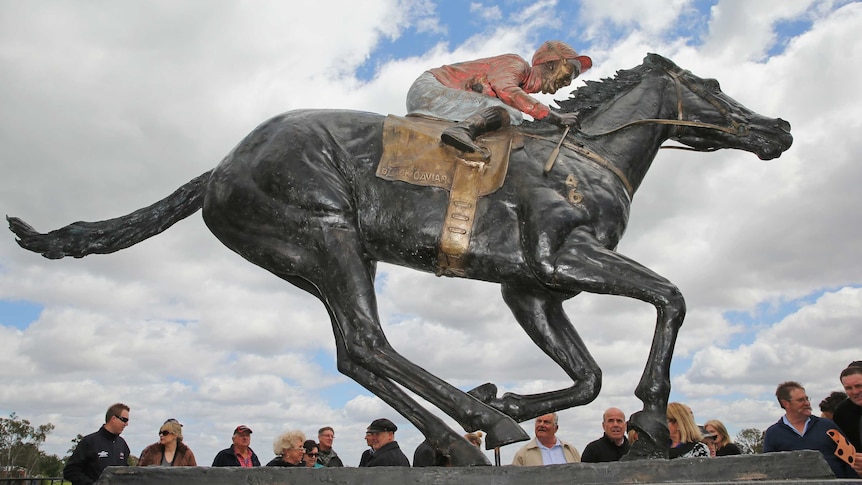 People have gathered for the unveiling of the Black Caviar statue in Nagambie, Victoria on 24 October 2013.