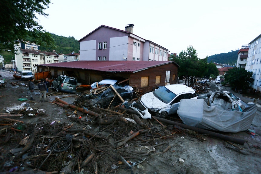 Samochody zniszczone na ulicy po powodzi i lawinie błotnej w miejscowości Bozkurt