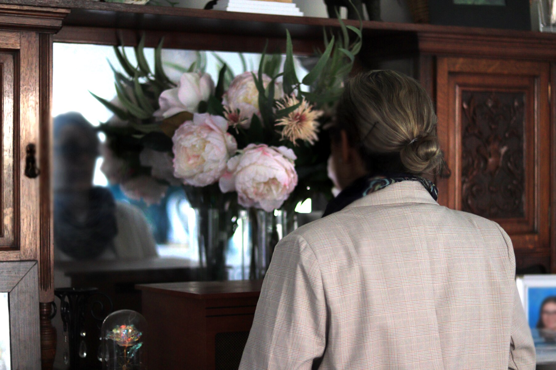 A dark and blurred image of a woman looking into a mirror