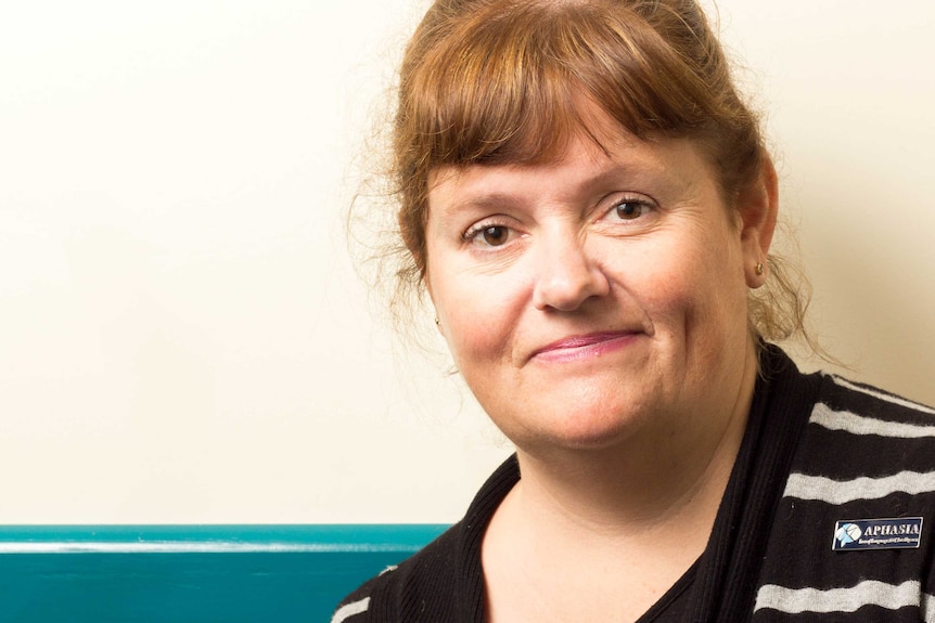 Caroline Matthews looks down the camera in front of a plain wall.