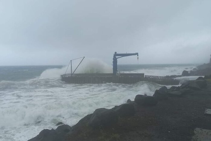 large waves crashing over cascade pier on nofrolk island 