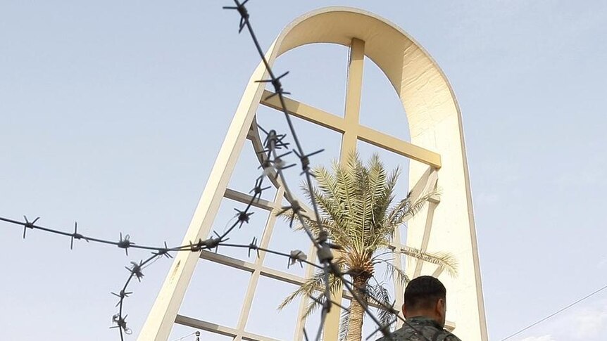 Iraqi security forces survey the scene outside the Sayidat al-Nejat Catholic Cathedral
