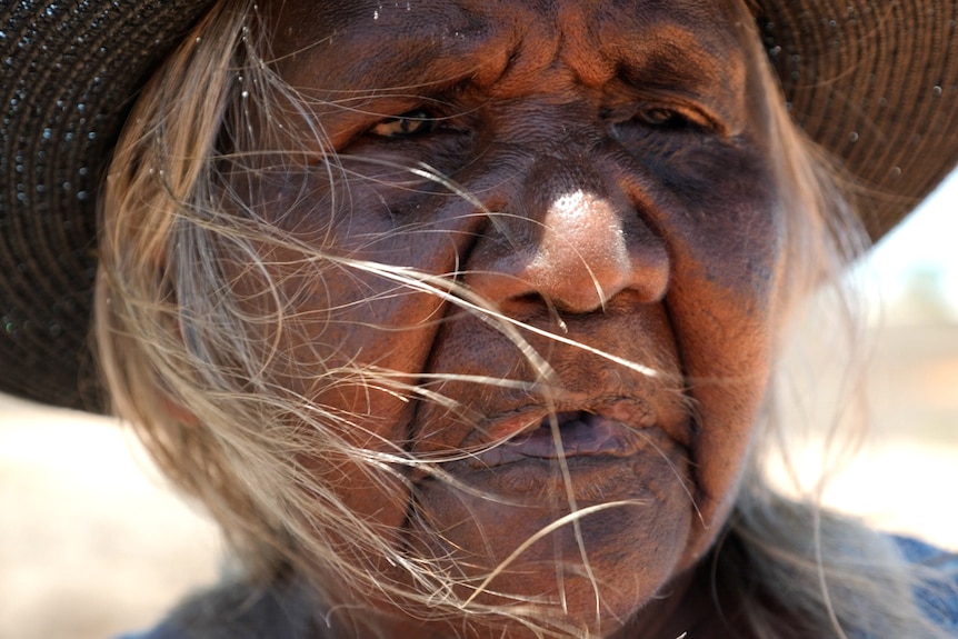 Close up of Kaidilt woman looking into distance, her eyes full of emotion.