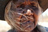 Close up of Kaidilt woman looking into distance, her eyes full of emotion.