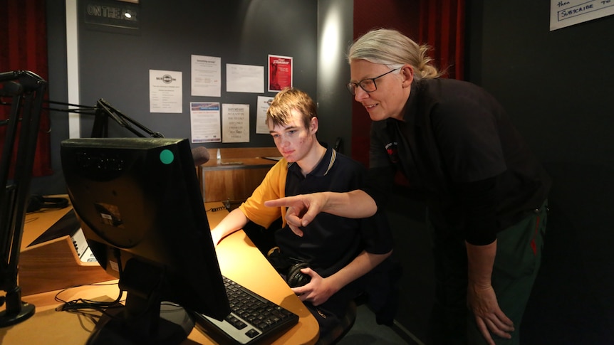 Teacher Louise Olsen showing student Ben how to use the digital editing software.